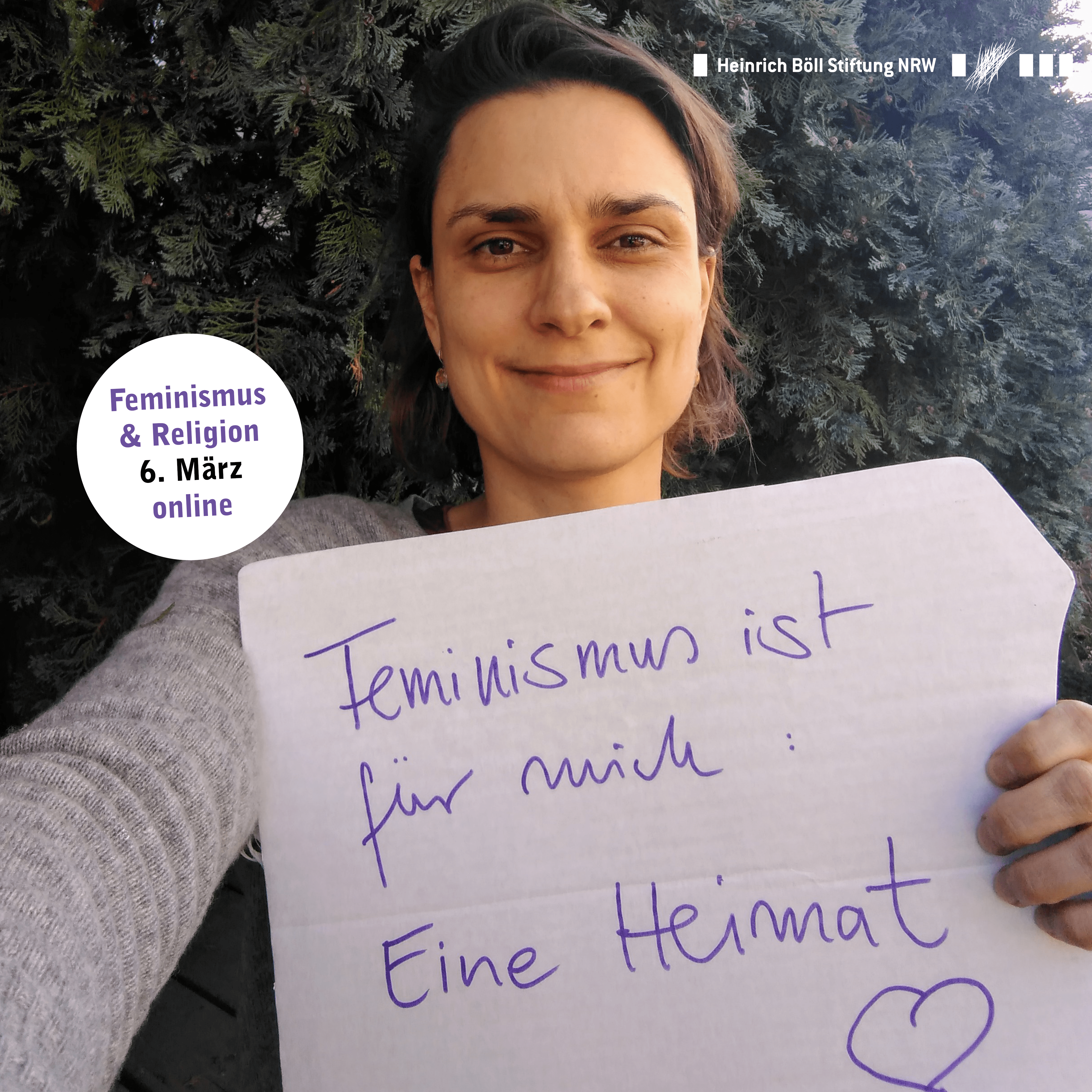 Eine Frau hält ein Schild in die Kamera auf dem steht: Feminismus ist für mich eine Heimat.