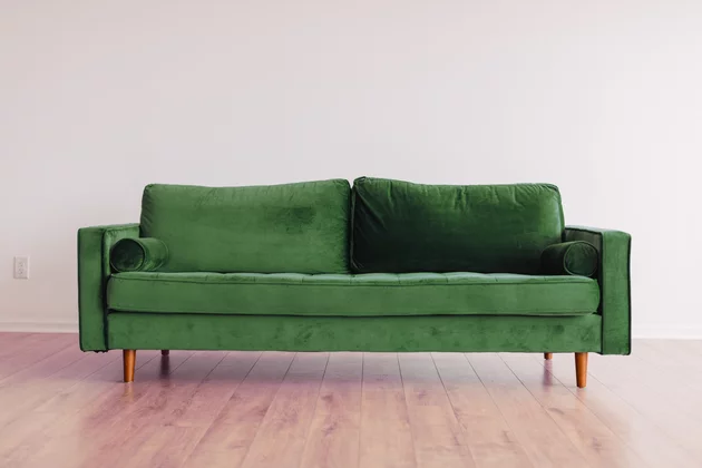 Ein grünes Sofa vor heller Wand.