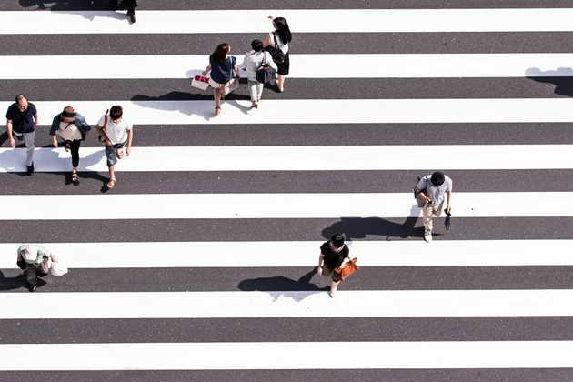 Menschen, die über einen langen Zebrastreifen gehen.