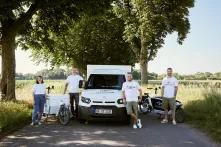 Vier Menschen in weißen Shirts, ein E-Laster und ein Lastenrad.