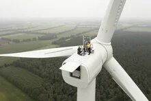 DAs Bild zeigt eine Gruppe von Menschen auf einem Windrad, von oben fotografiert.