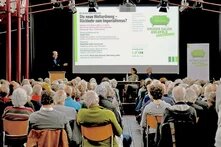 Das Bild zeigt das Publikum beim 50. Grünen Salon Bielfeld, auf der Bühne spricht Jürgen Trittin.