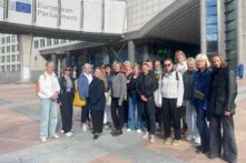 Das Bild zeigt eine Gruppe von FLINTA, die vor dem Europäischen Parlament in Brüssel stehen.