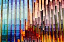 Das Bild zeigt bunte Farbproben in Papierform, die vond er Decke hängen. 