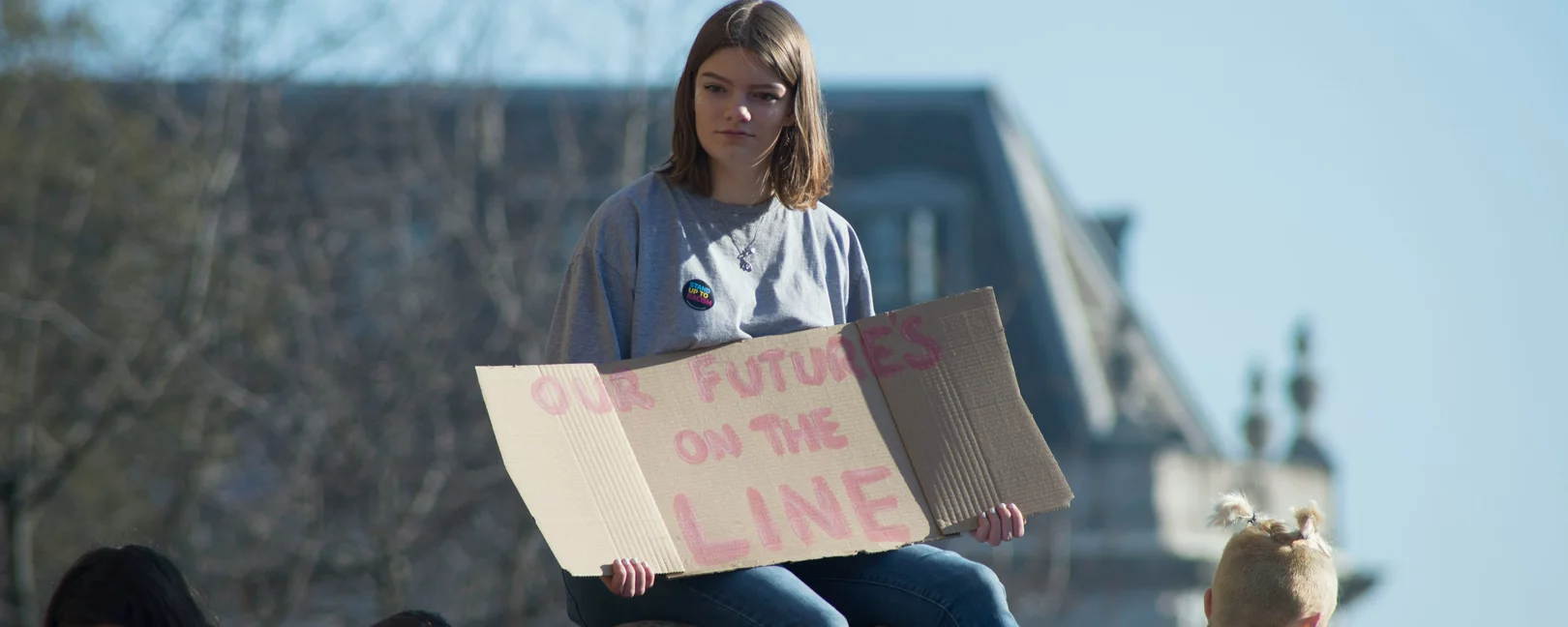 Frau mit Pappschild, auf dem steht: Our futures on the line.