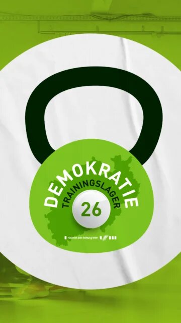 Eine grüne Kettlebell mit der Aufschrift Demokratie-Trainingslager 2026, dahinter ein verschwommenes Bild von Menschen, die sich durch einen Raum bewegen.