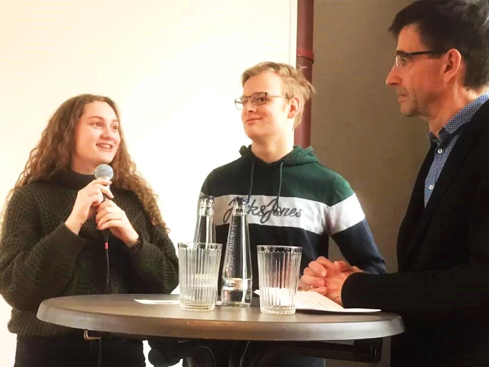 Mira Wegener und Maximilian Friebe (Grüne Jugend Bielefeld) im Gespräch mit Ulrich Burmeister (Grüner Salon Bielefeld) Gespräch auf dem Podium beim Grünen Salon Bielfeld